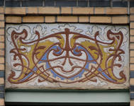 Peter Benoitstraat 2-4 en Waversesteenweg 517-519 Etterbeek, afgeschuinde travee, sgraffito op de borstwering van de tweede verdieping (© APEB, foto 2016).